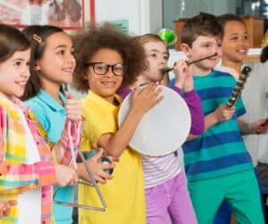 Children singing and playing musical instruments.