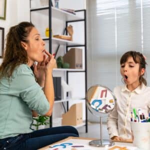 Girl and pediatric speech-language pathologist working together.
