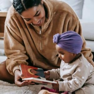 Mother sharing a picture book with her infant.