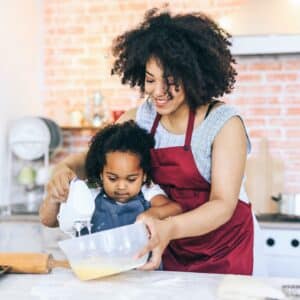 Mother and preschool daughter cooking together. Mother is modeling language.