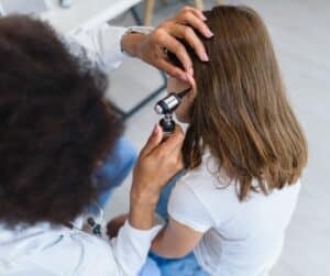 Child with ear infection being examined by doctor.