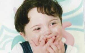 Little boy using a gesture with hands near face.